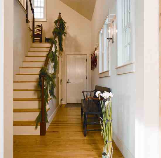 The Shaker-railed stairway climbs to the guest bedroom that Cathy uses as a music studio. The door leads to the home’s “sunset” porch, an ideal place for watching the ebbing colors of a wintry sky.